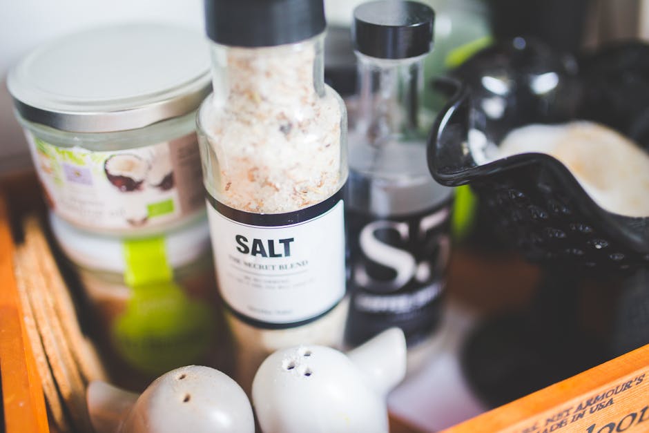 Close-up view of various kitchen condiments, featuring salt shaker and other containers.