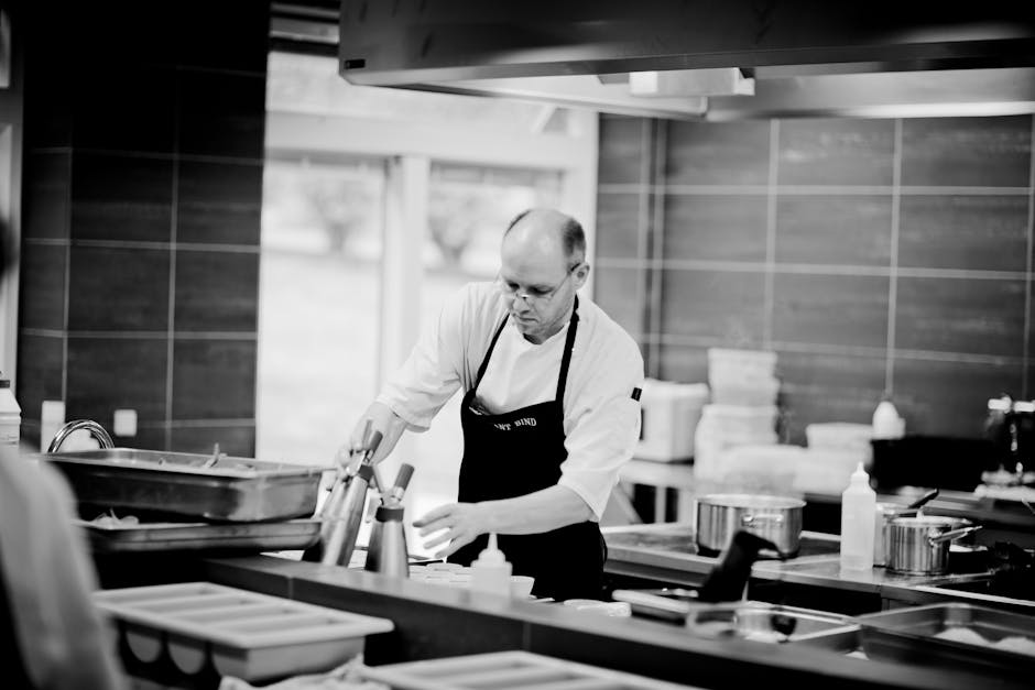 Chef in a restaurant kitchen carefully preparing dishes with attention to detail