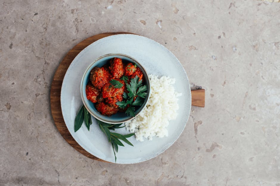 Delicious Asian-style meatballs with rice, garnished with herbs, on a textured plate
